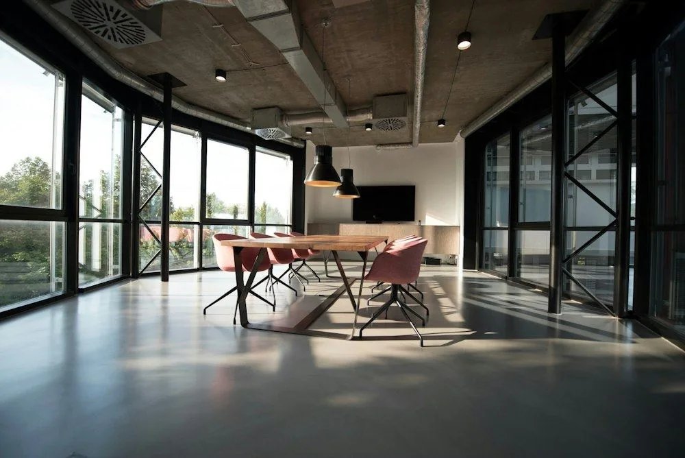 Sunlit office meeting space with large windows
